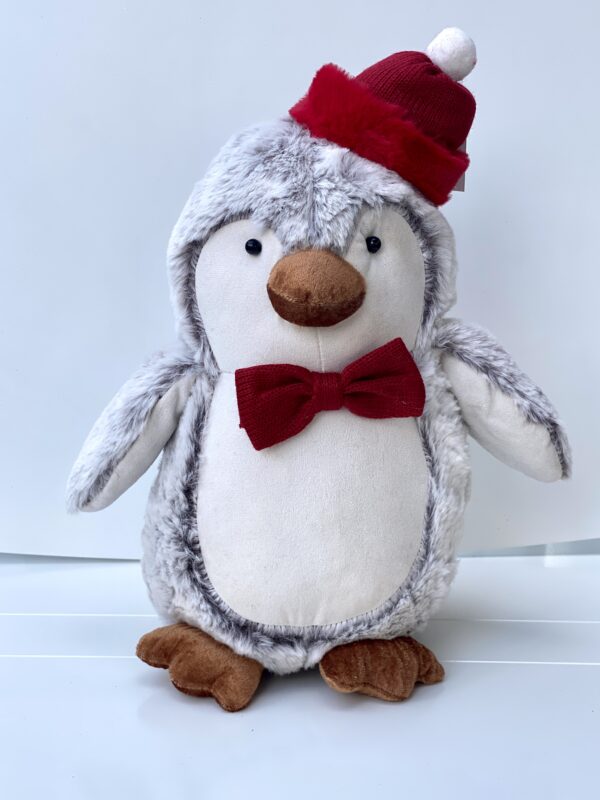 a stuffed penguin wearing a red hat and bow tie